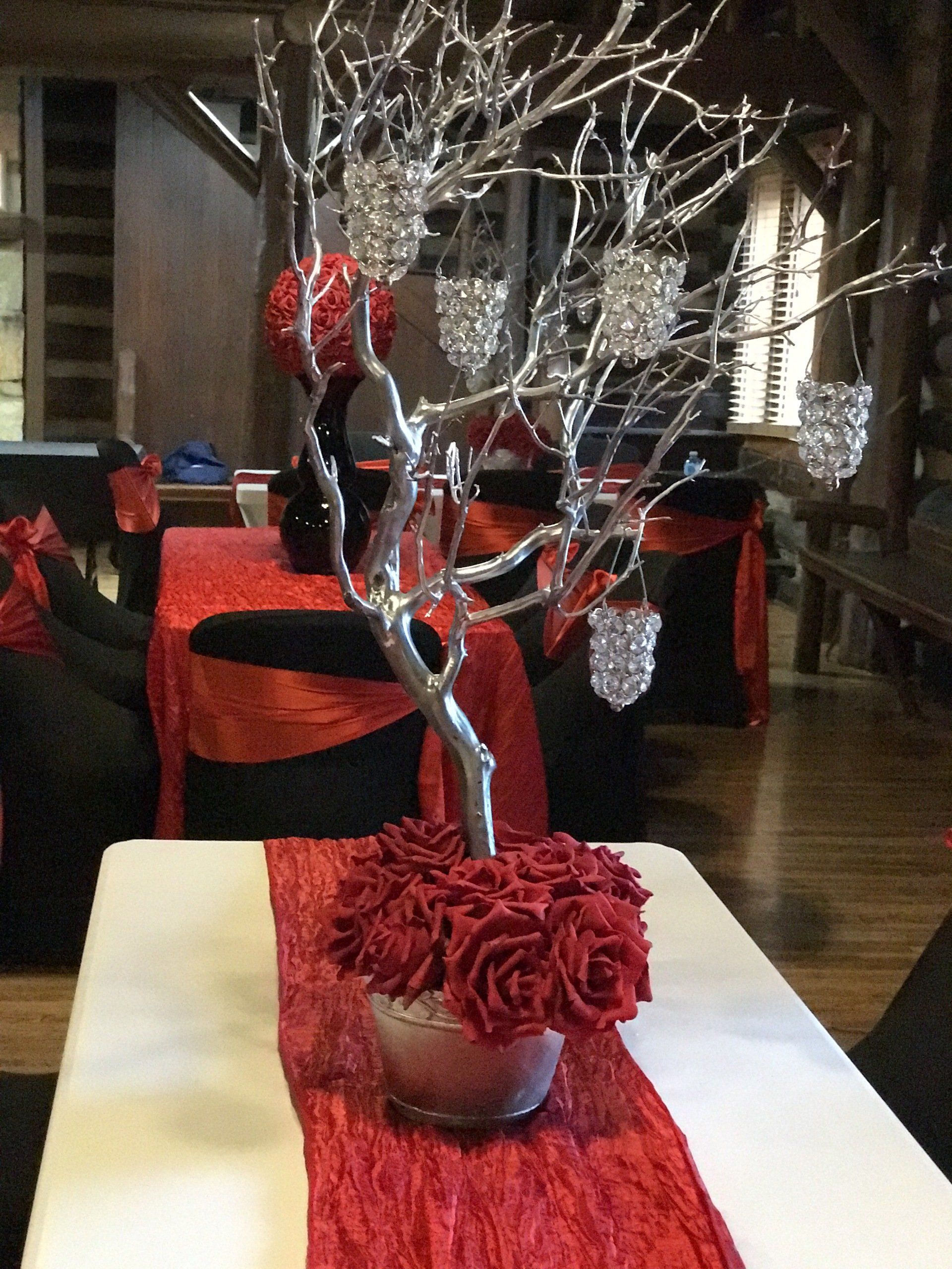 silk roses at the base on a crushed red table runner.