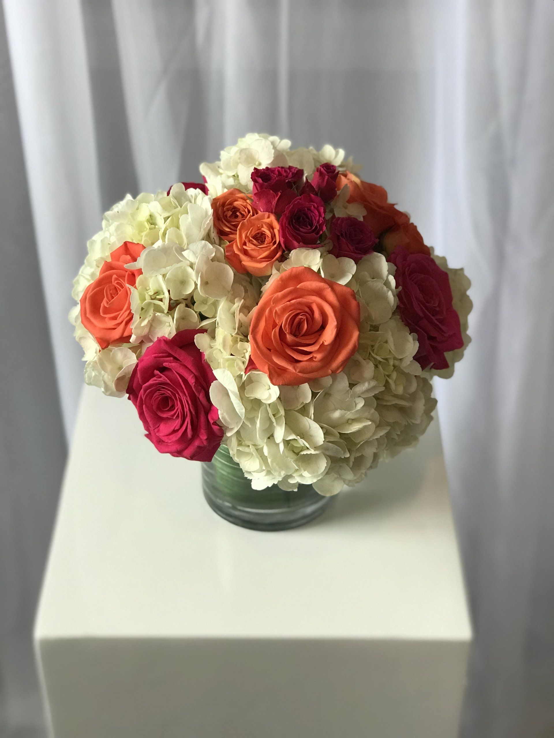 Close up of floral centerpiece in a short glass cylinder.