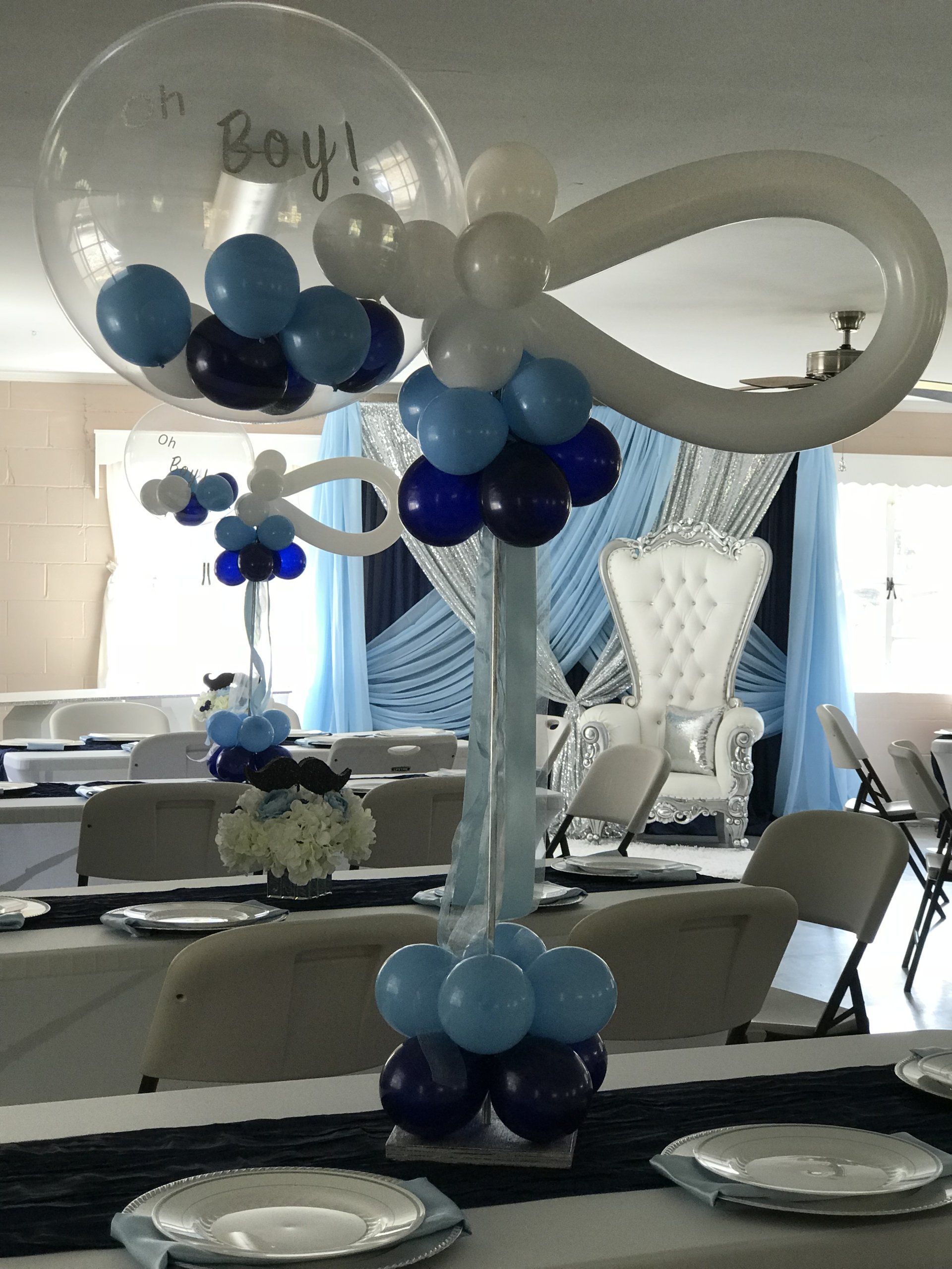 Tall balloon centerpieces in the theme of a baby boy with a rattle design at the top.