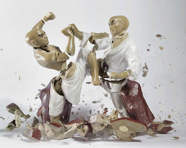 A karate figurine is being kicked by another figurine