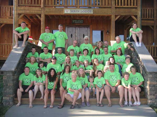 A group of people posing for a picture in front of a main lodge