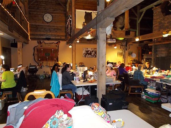 A group of people are sitting at tables in a room with a clock on the wall