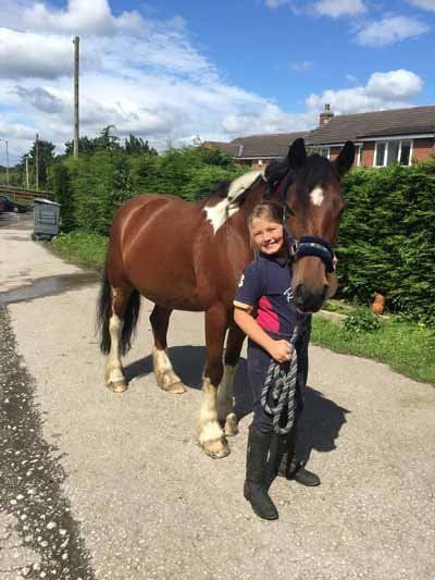 a girl stand with horse