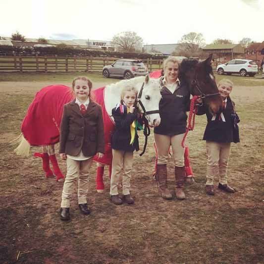 4 childrens stand with a horse