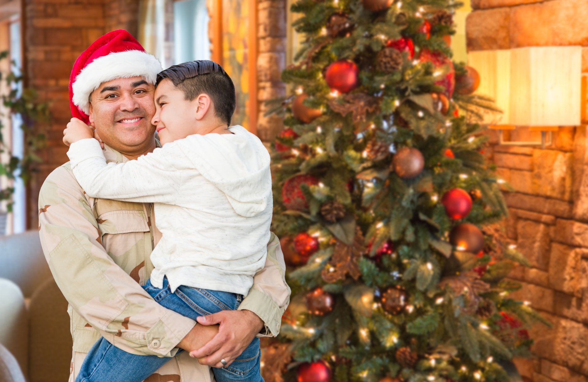 Soldier holding his son by a Christmas tree. Soldier holding his son by a Christmas tree.