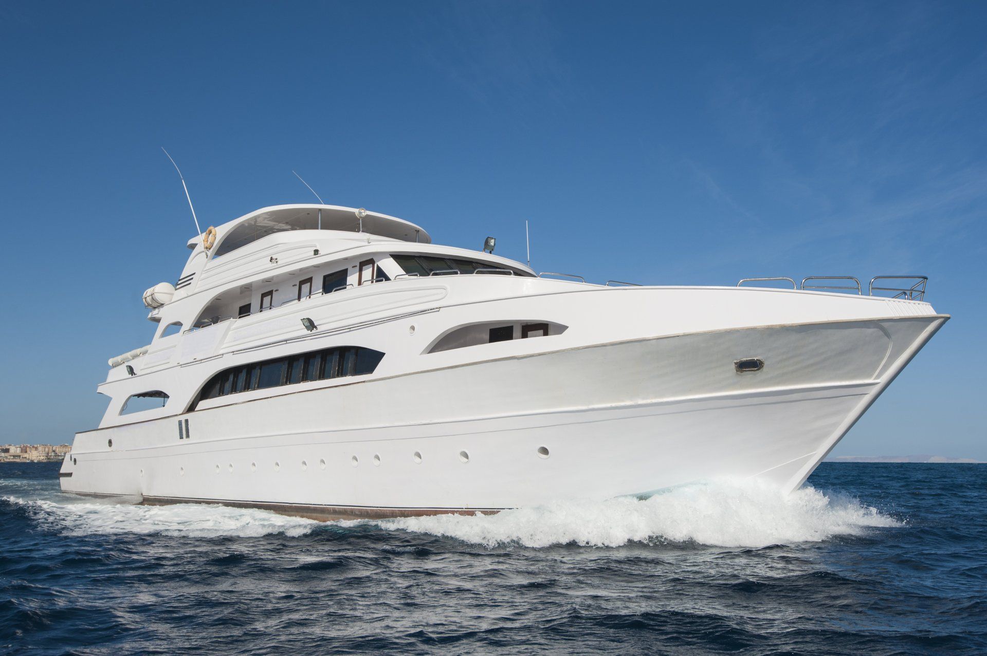 A large private motor yacht under way sailing out on tropical sea