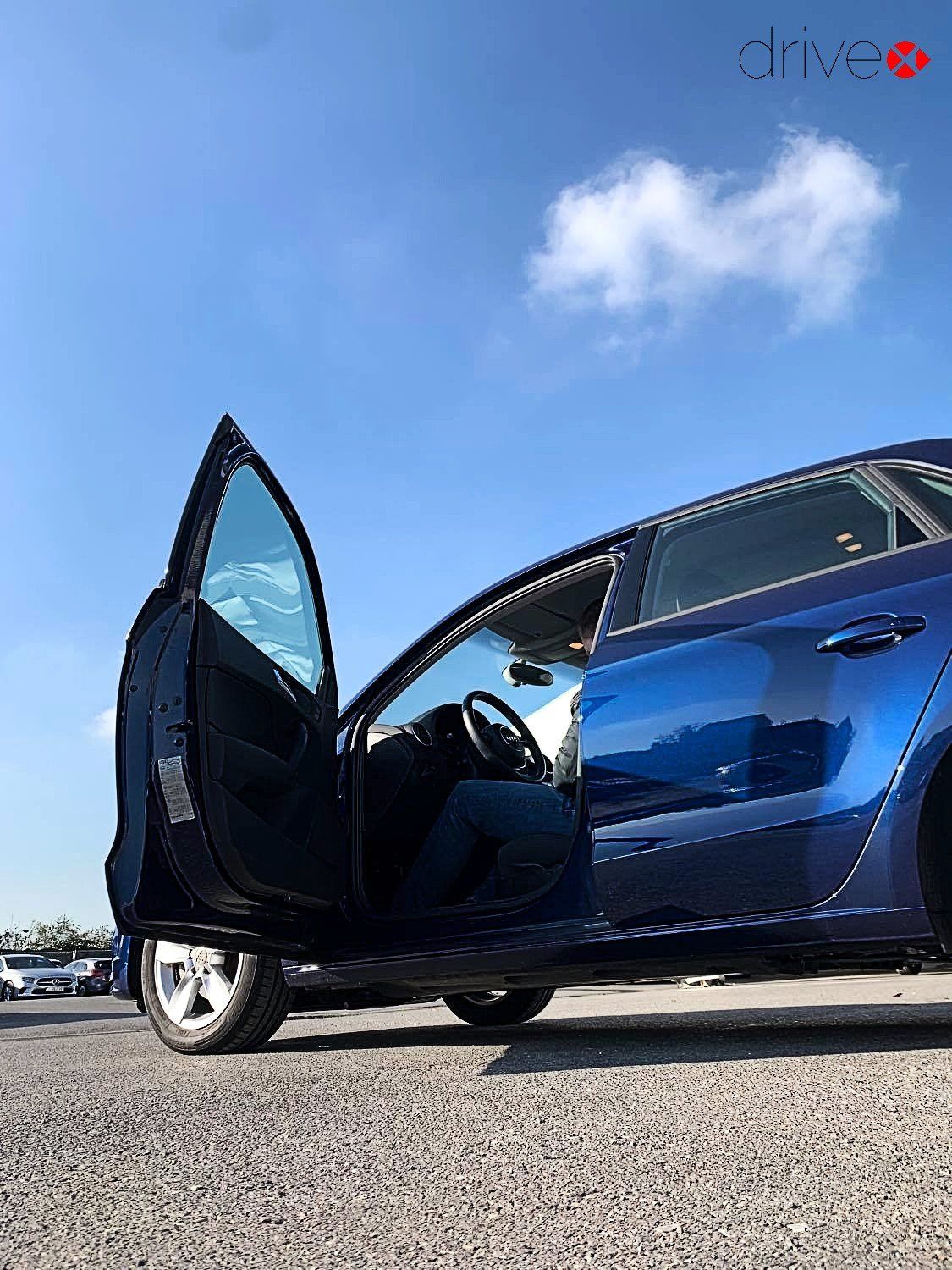 Damage advisor of Drivex sitting in a blue car to check it on damages.