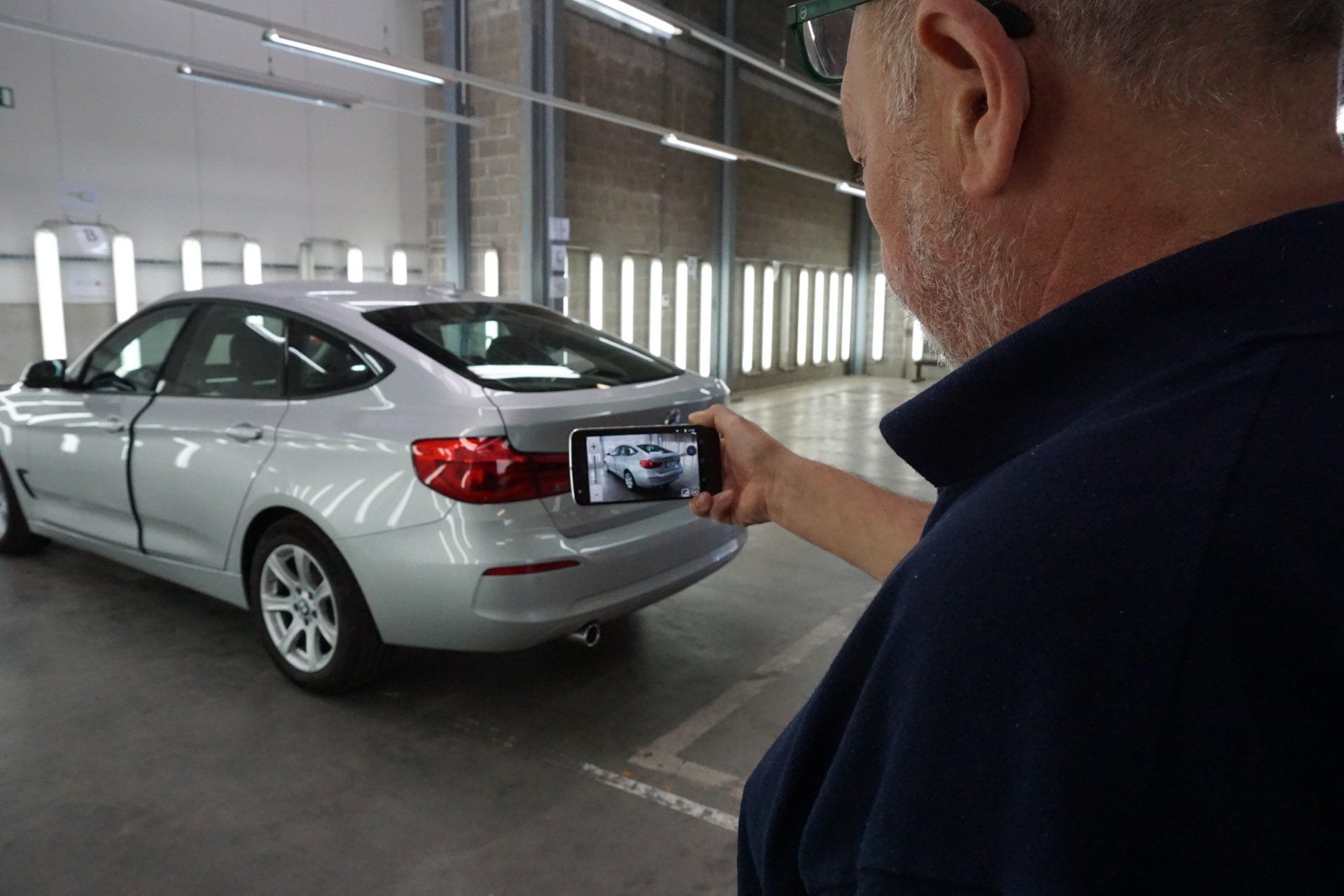 Damage advisor of Drivex taking a picture of a vehicle.