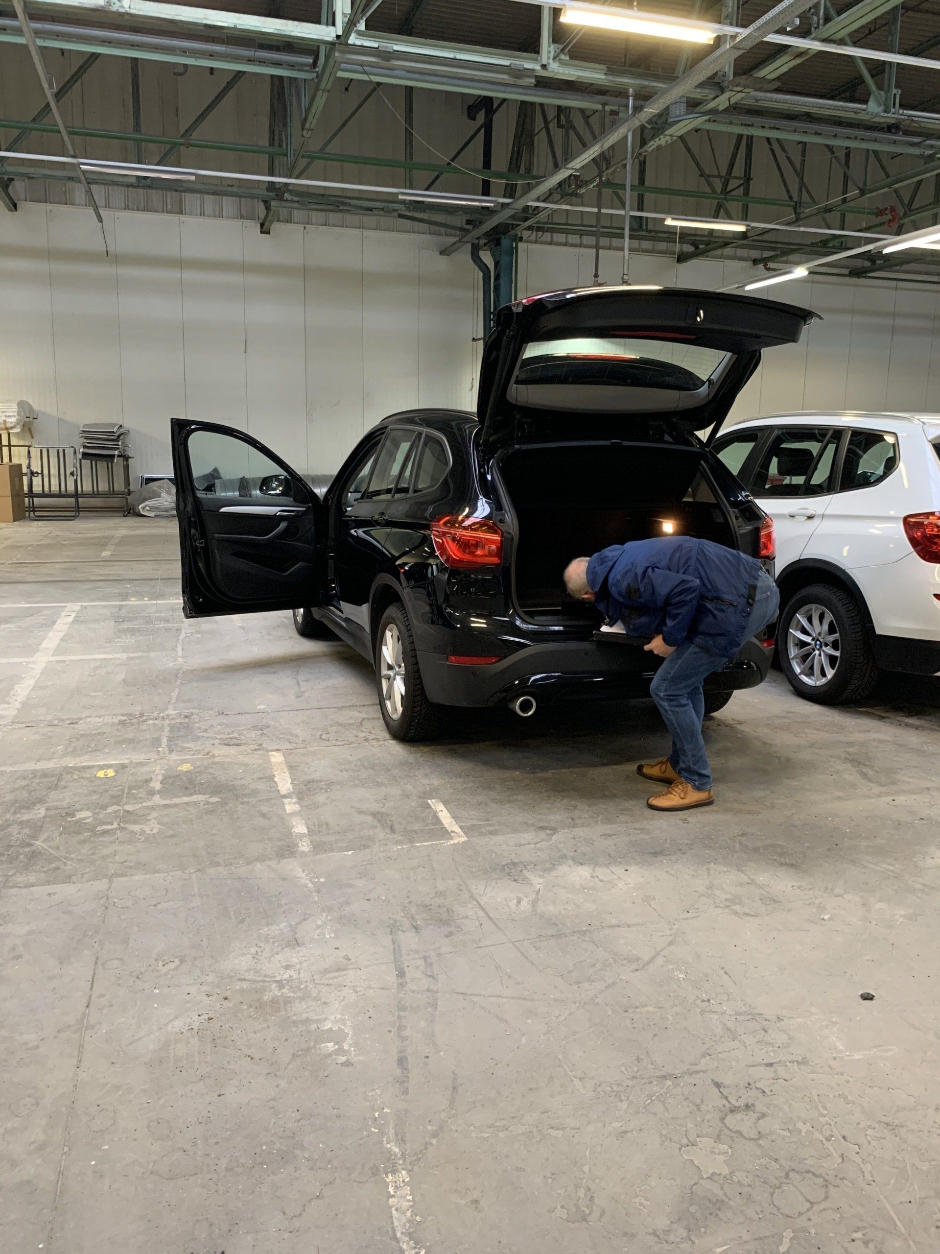 Photo of driver checking a vehicle on damages.