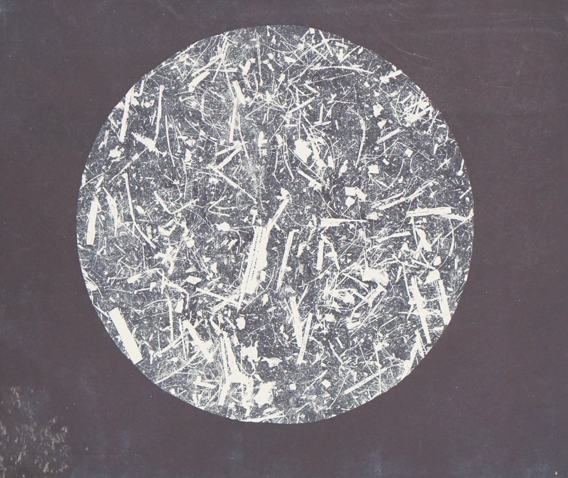 Circle of white, textured marks on a dark gray background.