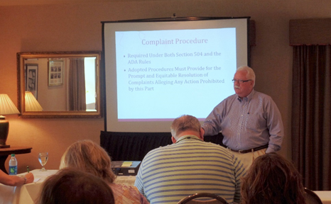 “Training session with presenter and slide on ADA complaint procedures.”