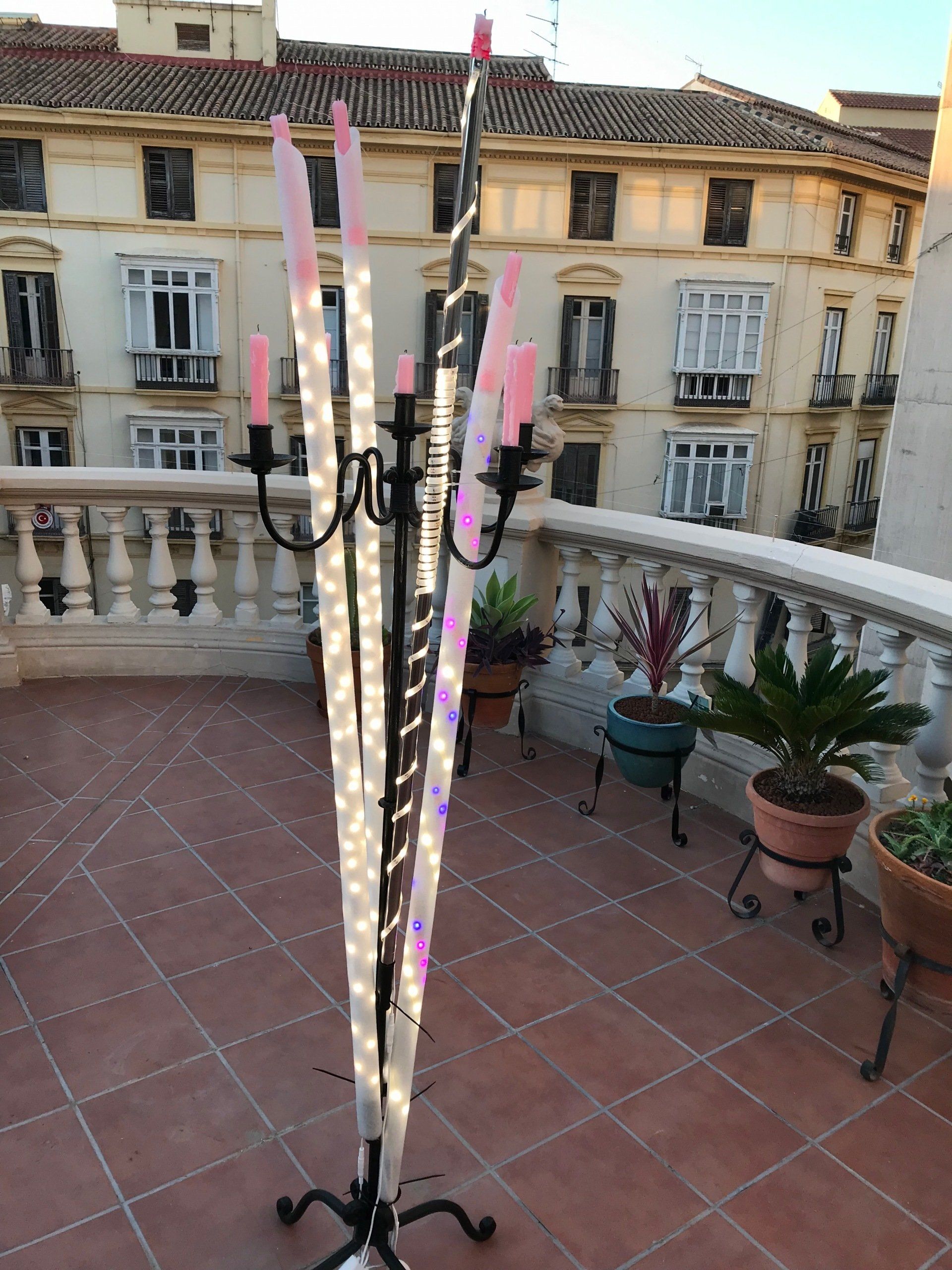 Ein Kandelaber mit Kerzen darauf steht auf einem Balkon