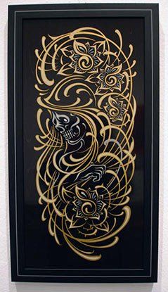 A black and gold painting is hanging on a wall.