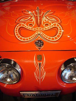A red car with a snake painted on the hood