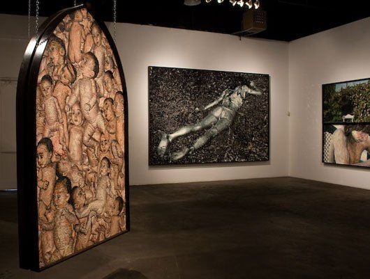 Display of Mondongo art on white walls of an art gallery.