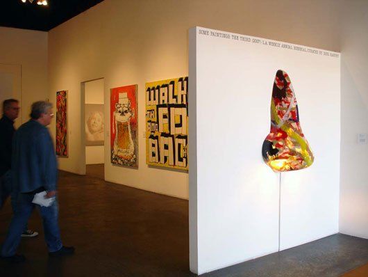 Two men are looking at a painting that says walk the fd bag