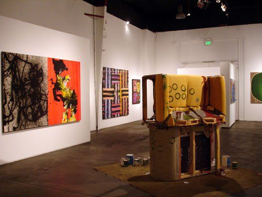 A room with paintings on the walls and a yellow object in the middle