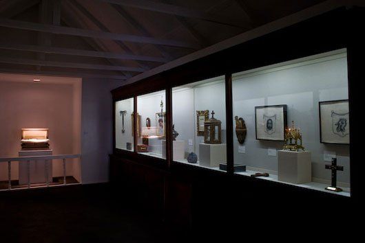 A display case with a cross on it in a dark room