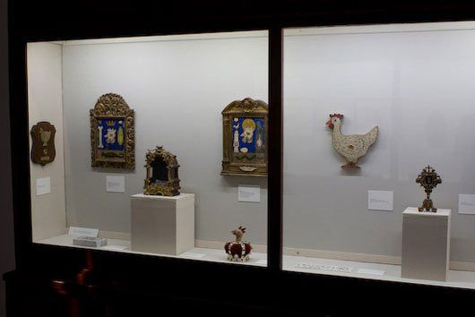 A display case with a chicken and a clock on it