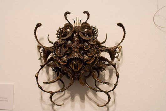 A sculpture is hanging on a white wall