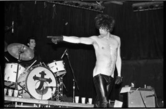A man is pointing at a drum with a cross on it