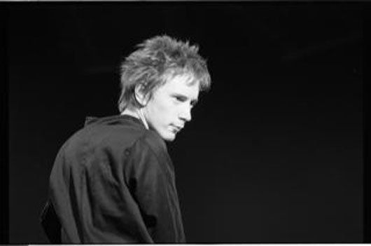 A black and white photo of a man in a black shirt