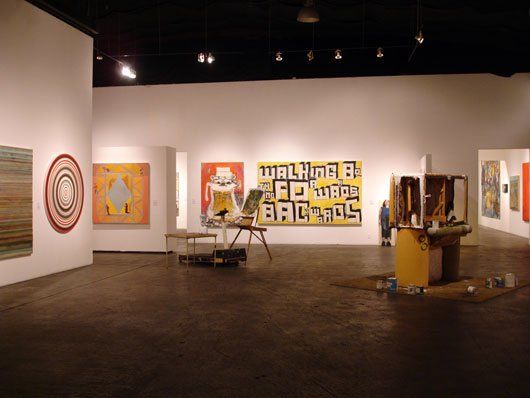 A large room with paintings and a sign that says walking by