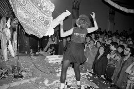 A woman is dancing on a stage in front of a crowd.