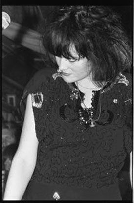 A black and white photo of a woman in a black dress.