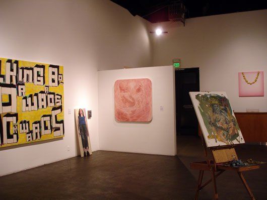 A room with paintings on the wall and a sign that says 