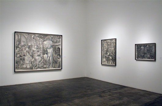 A room with three paintings hanging on the wall.
