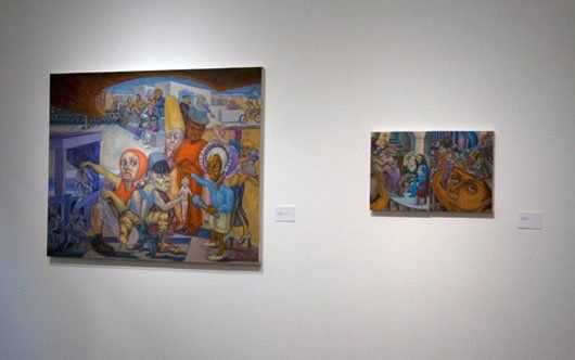 Two paintings are hanging on a white wall in Track 16 Gallery.