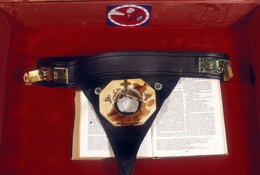 A red box with a belt on top of a book