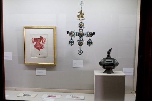 A display case with a picture and a cross on the wall