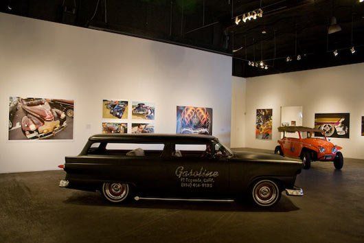 A black station wagon is parked in a museum.