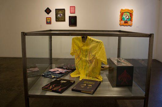 A display case with a yellow shirt and books on it