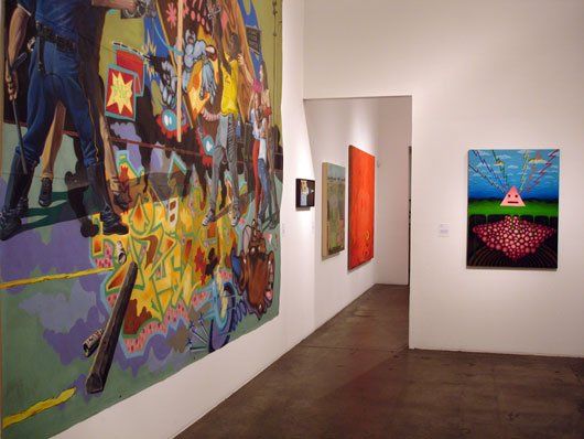 A hallway with paintings on the wall and a large painting on the wall.