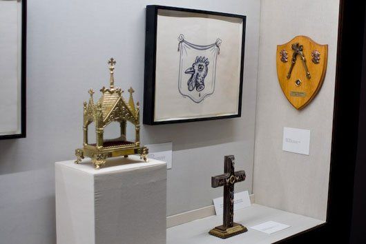 A cross and a shield are on display in a museum