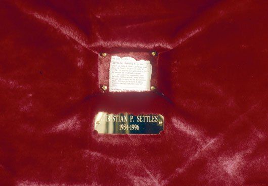 A close up of a red item with a plaque on it that says stan f. settles
