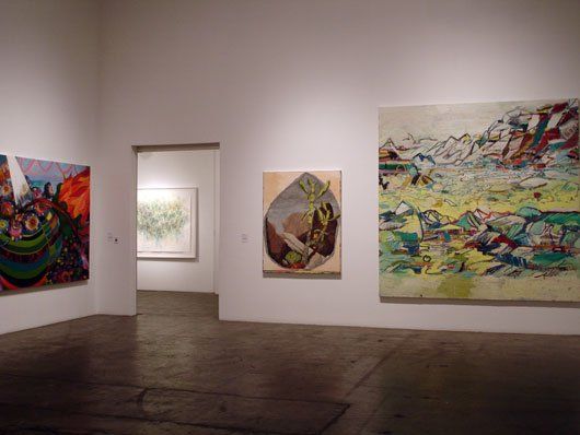 There are many paintings on the wall in this room.