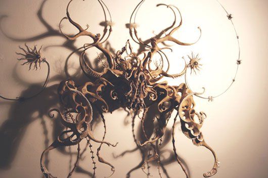 A close up of a sculpture with a shadow on a wall