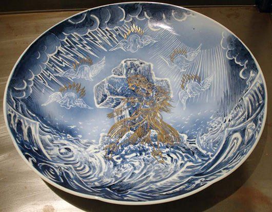 A blue and white plate with a drawing of a man in the water on it.