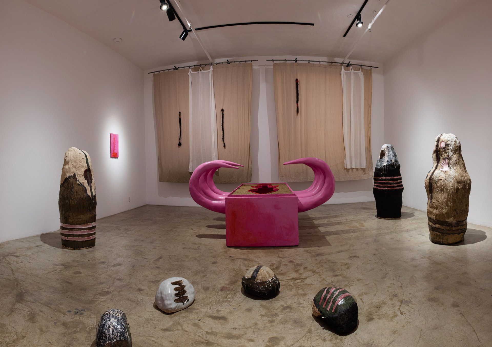 A room with a lot of sculptures on the floor and walls.