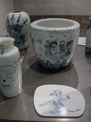 A display of blue and white vases and a plate with a mouse on it