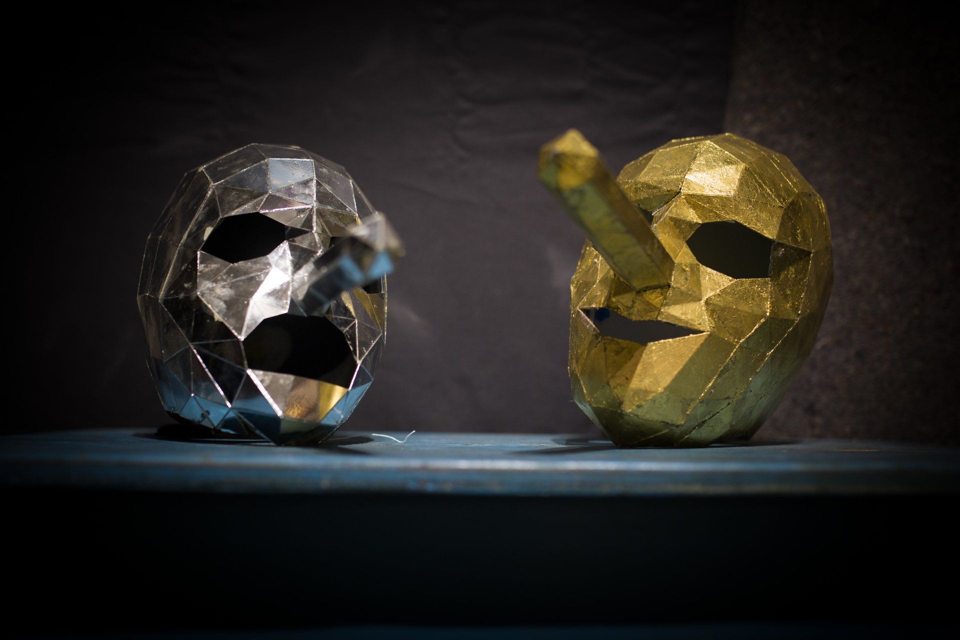 Two masks are sitting next to each other on a table.