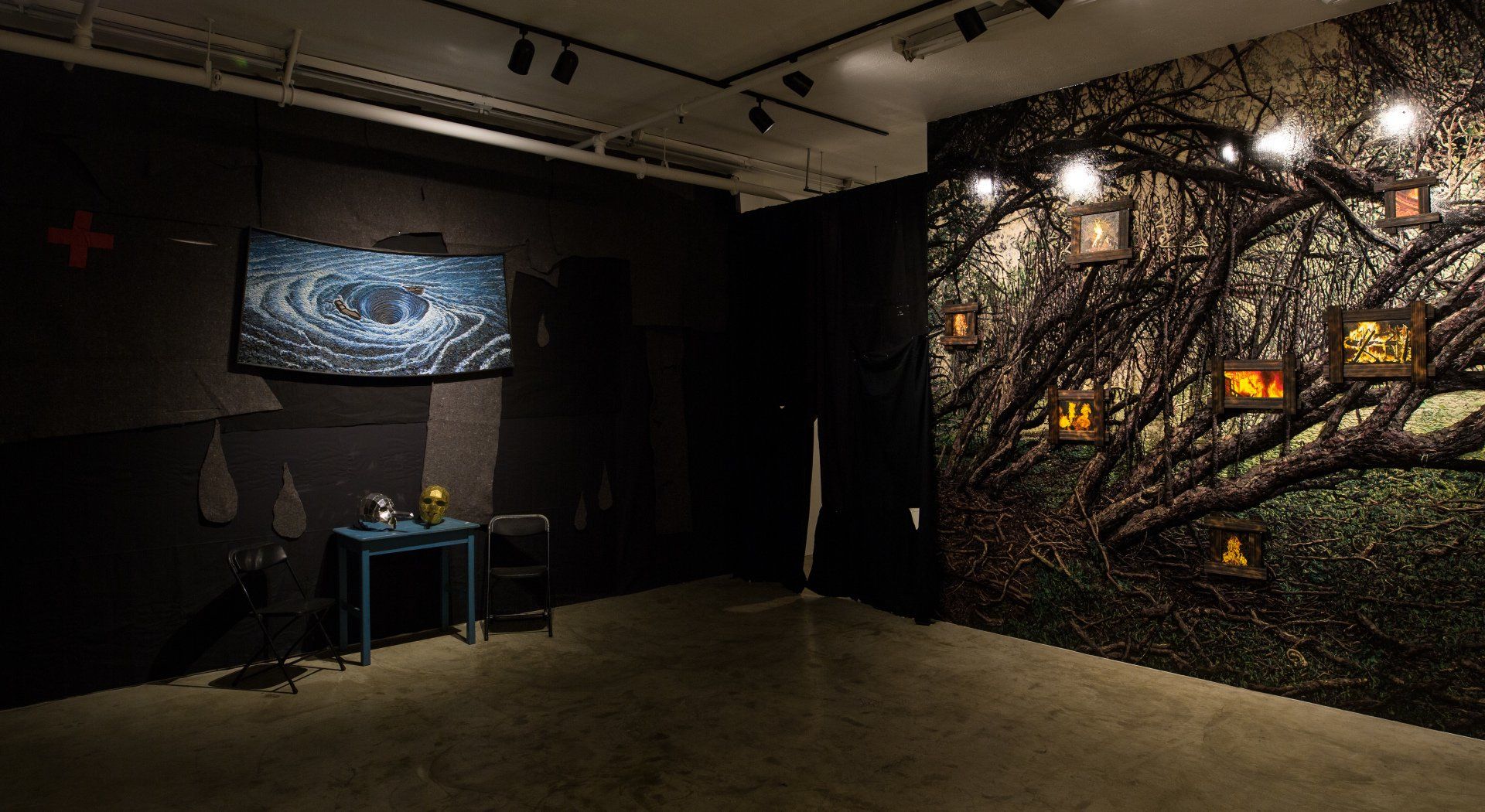 A dark room with a table and chairs and a painting on the wall.