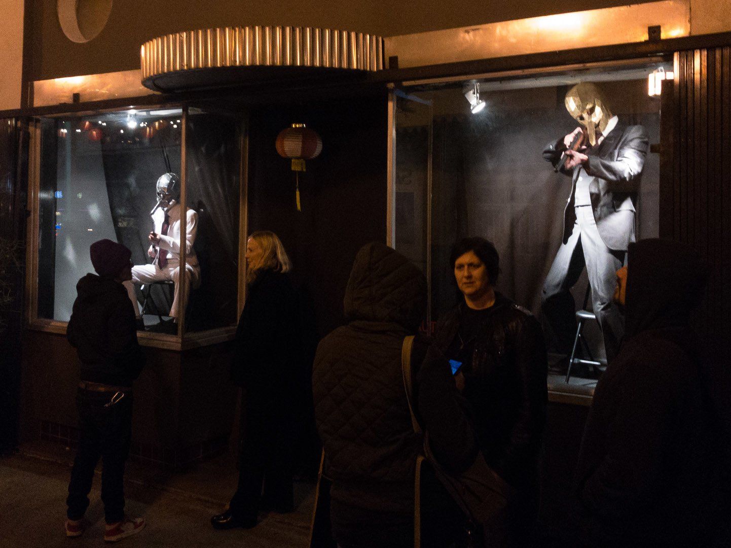 A group of people are standing in front of a store window