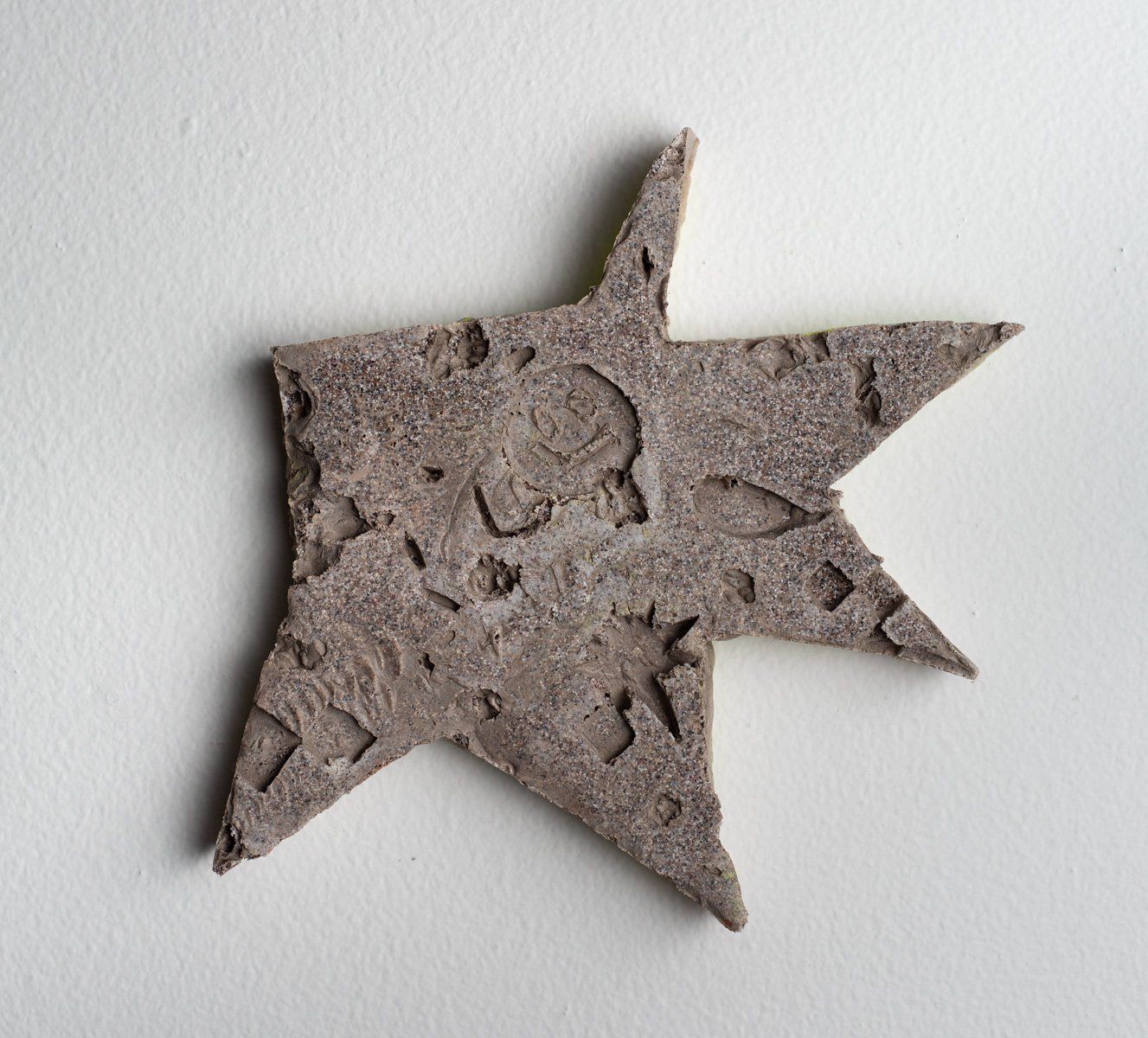 A gray star shaped piece of paper on a white surface