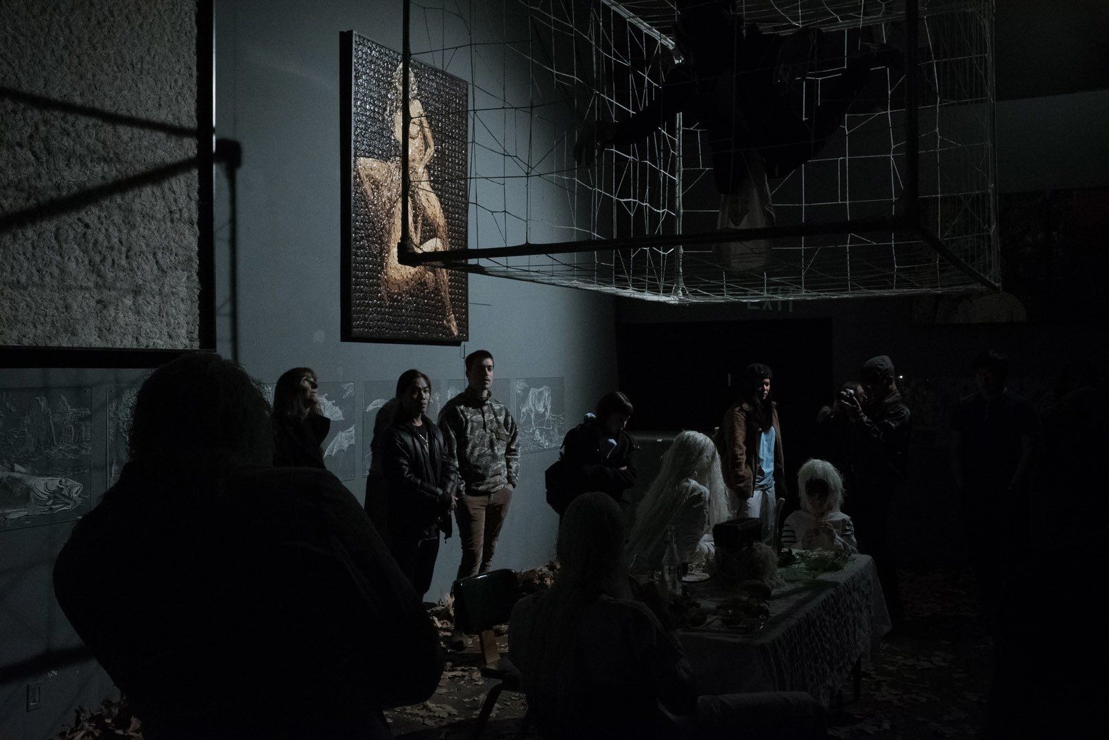 A group of people are standing around a table in a dark room.