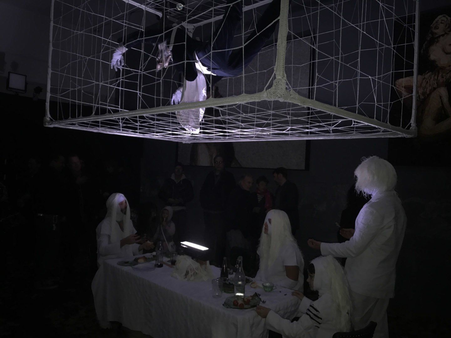 A group of people are sitting around a table in a dark room.